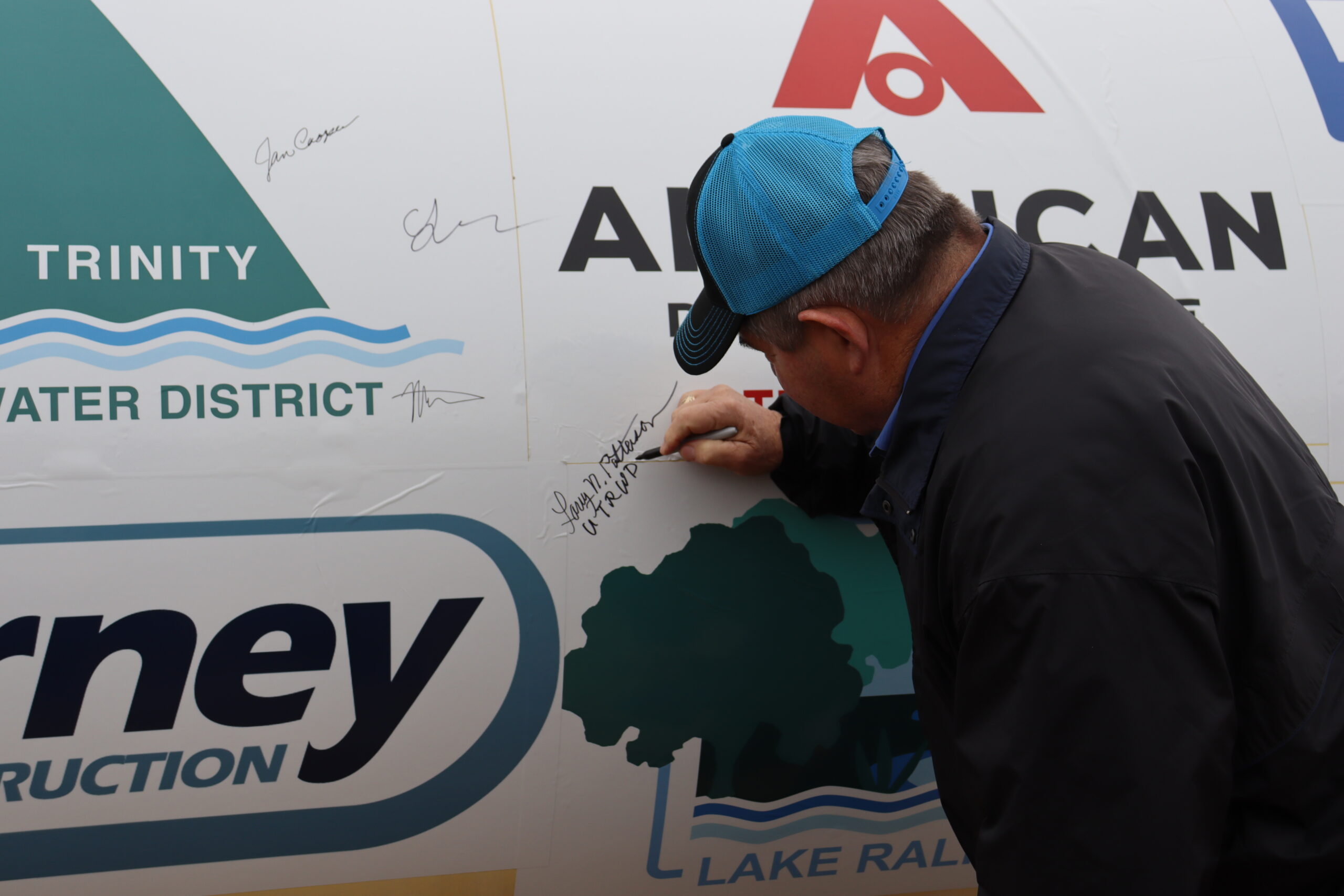 Upper Trinity director Larry Patterson signs commemorative piece of pipe