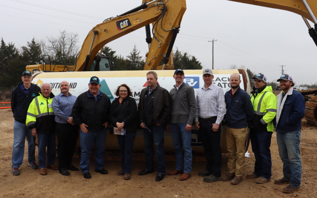 Upper Trinity team members, contractors and city/county officials pose in front of last piece of pipe with logos of all participants February 2025